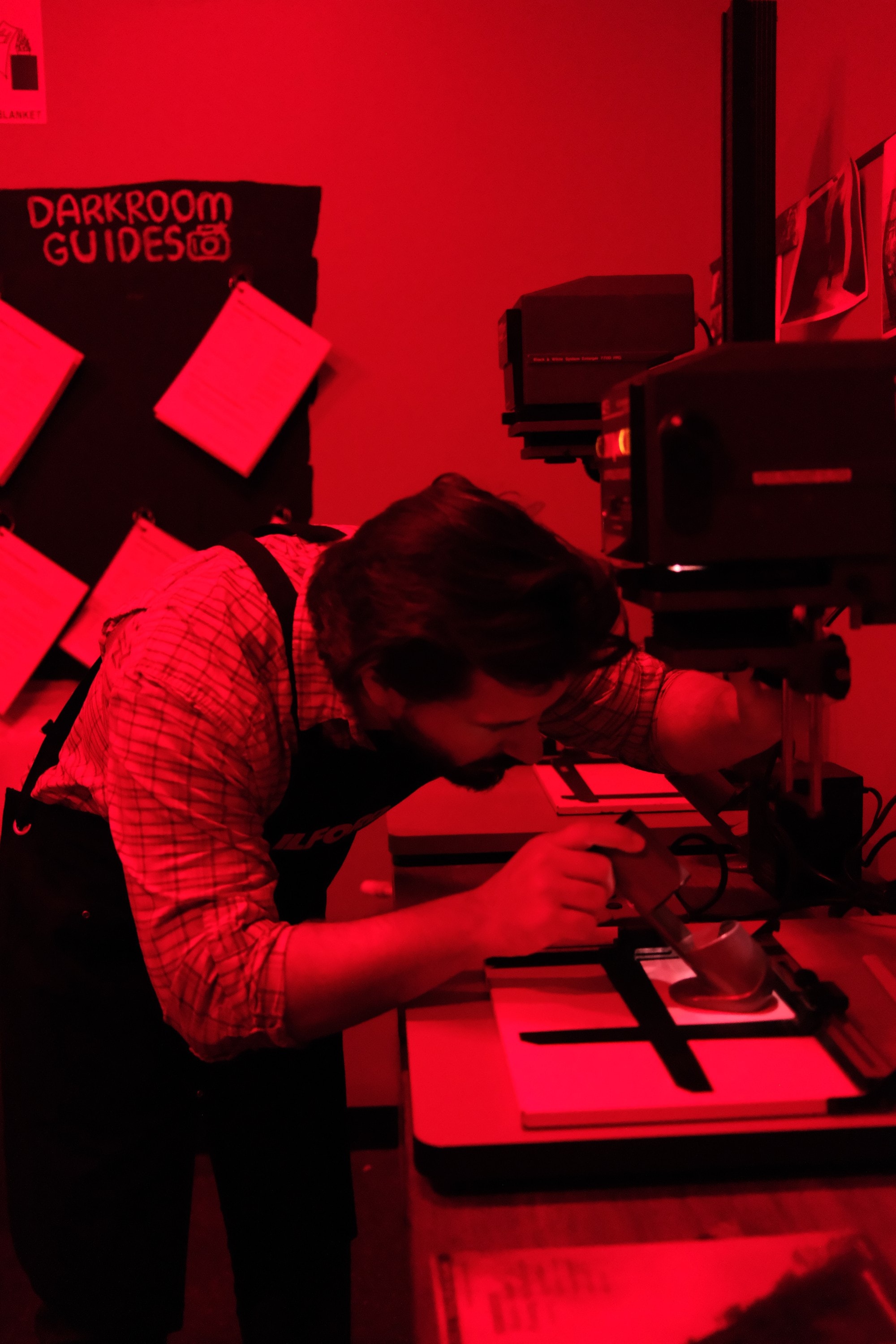 Dillon leaning in over the easel beneath the enlarger