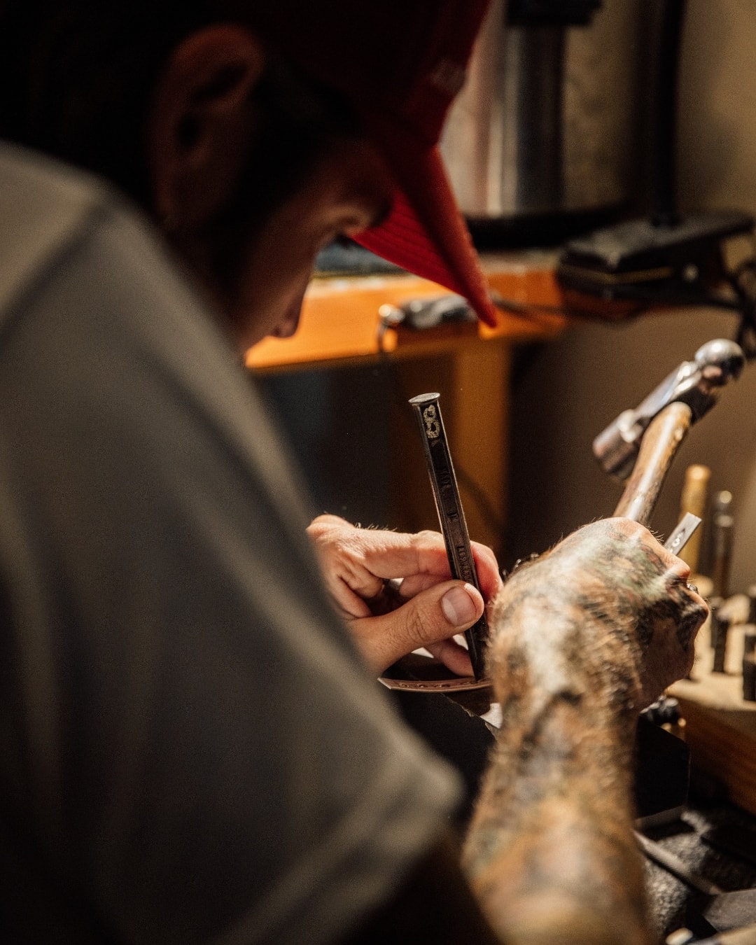 Adam stamping a piece of silver with a hammer