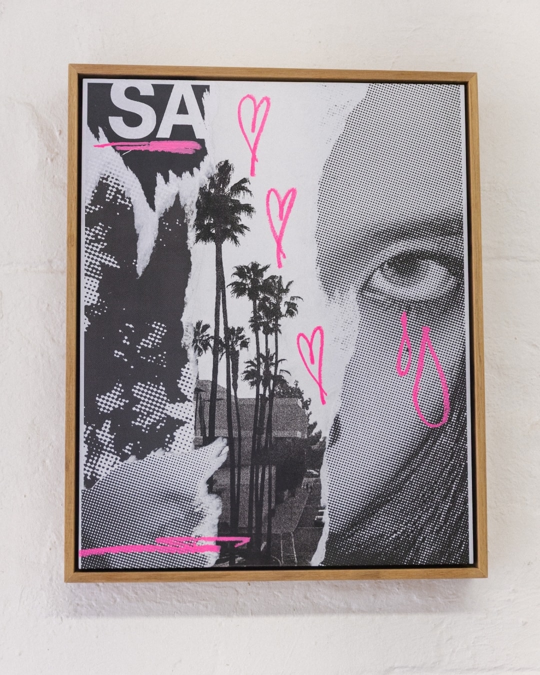 A framed collage by Chico Leong: palm trees and a large eye in halftone black and white, with pink hand-drawn hearts