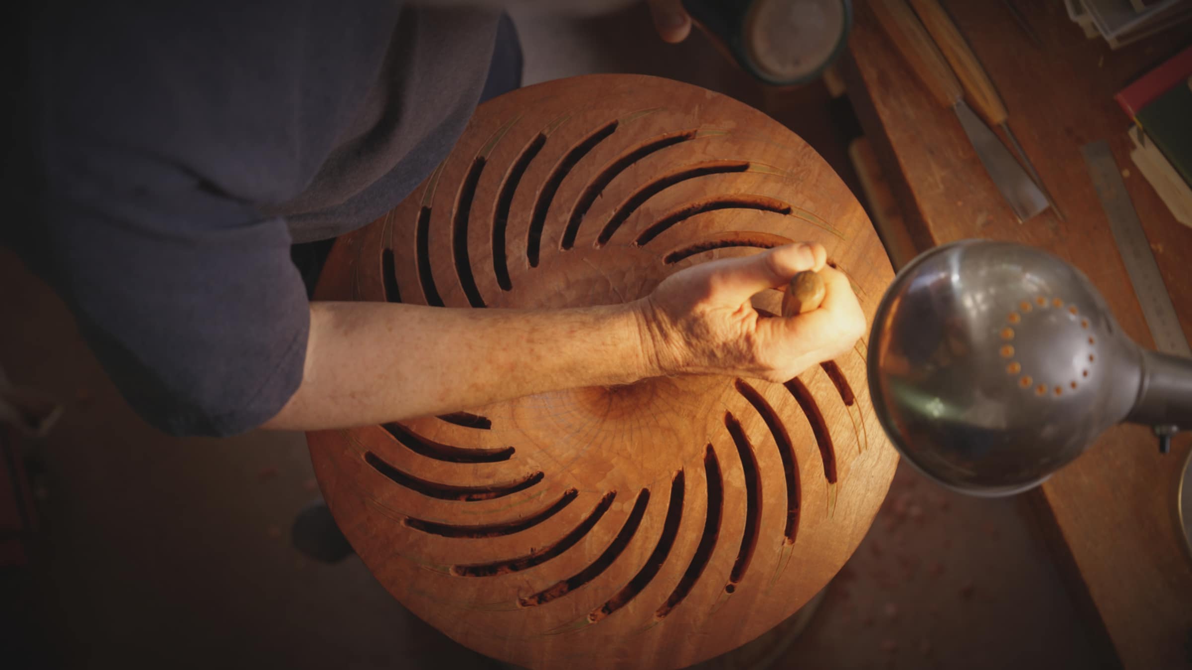 Robert carving the slots of a bowl, seen from above