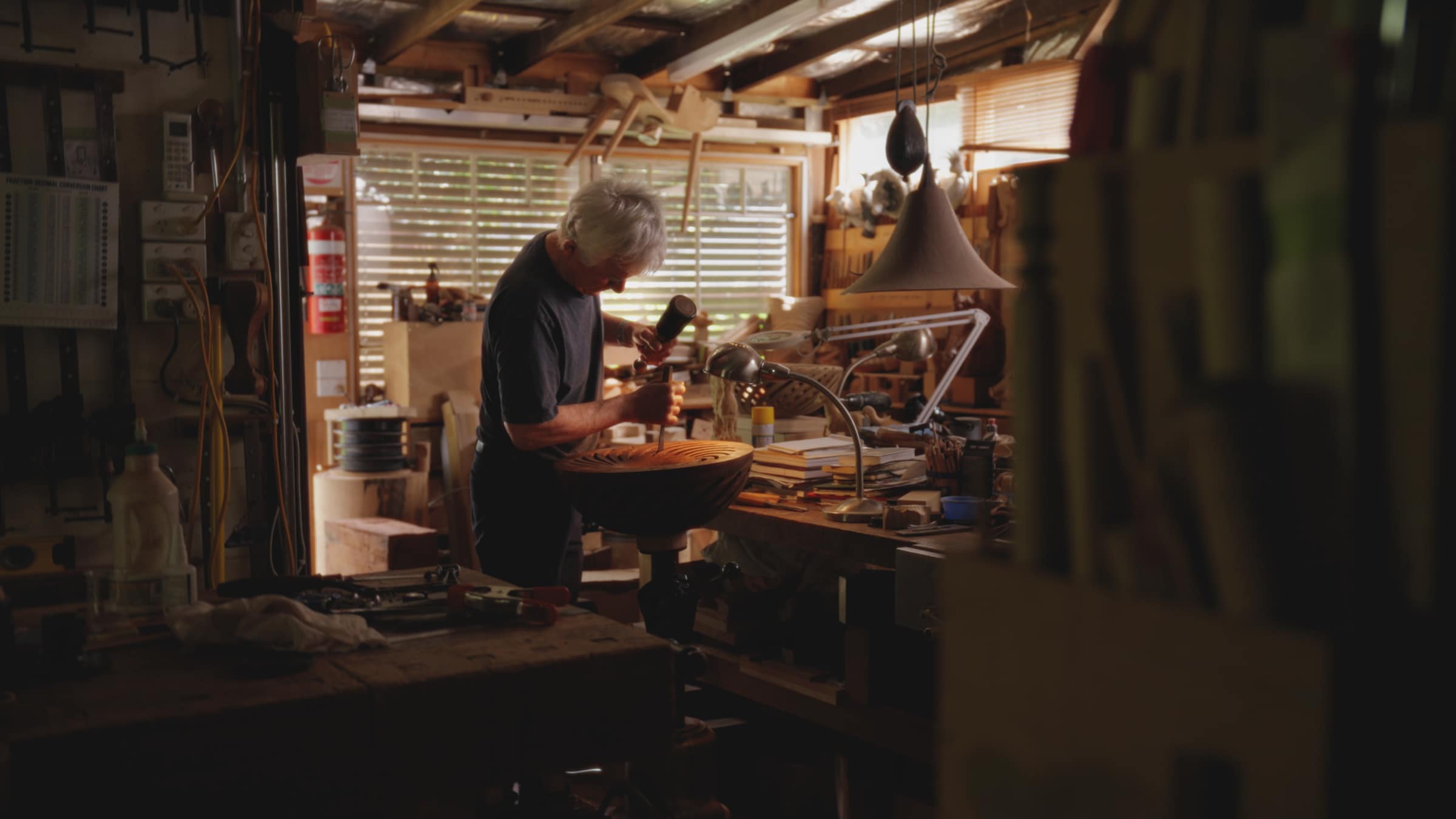 Robert at work in his crowded workshop, light coming through the window