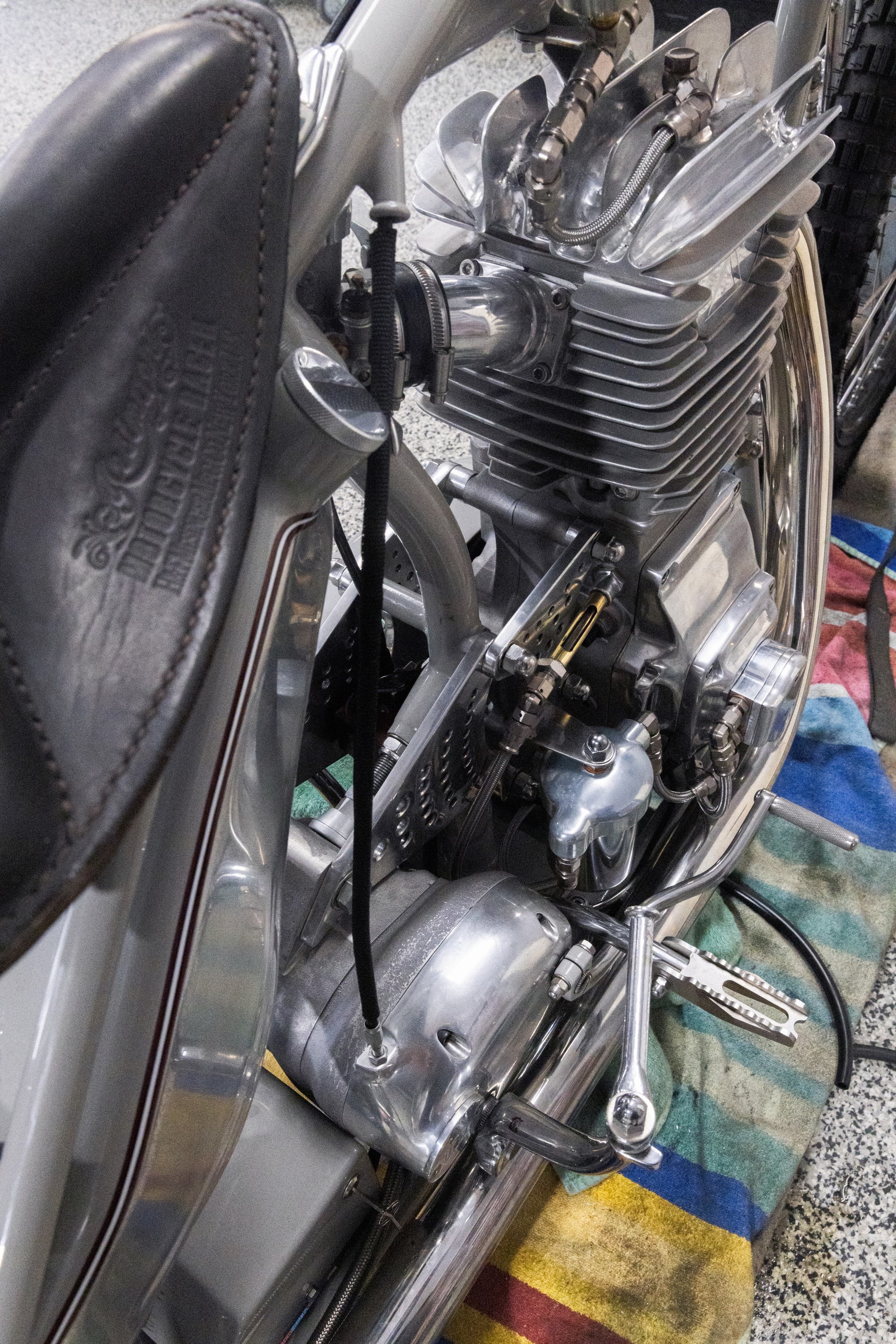 The engine, leather seat and polished aluminium of a custom motorcycle in Tom Gilroy’s workshop