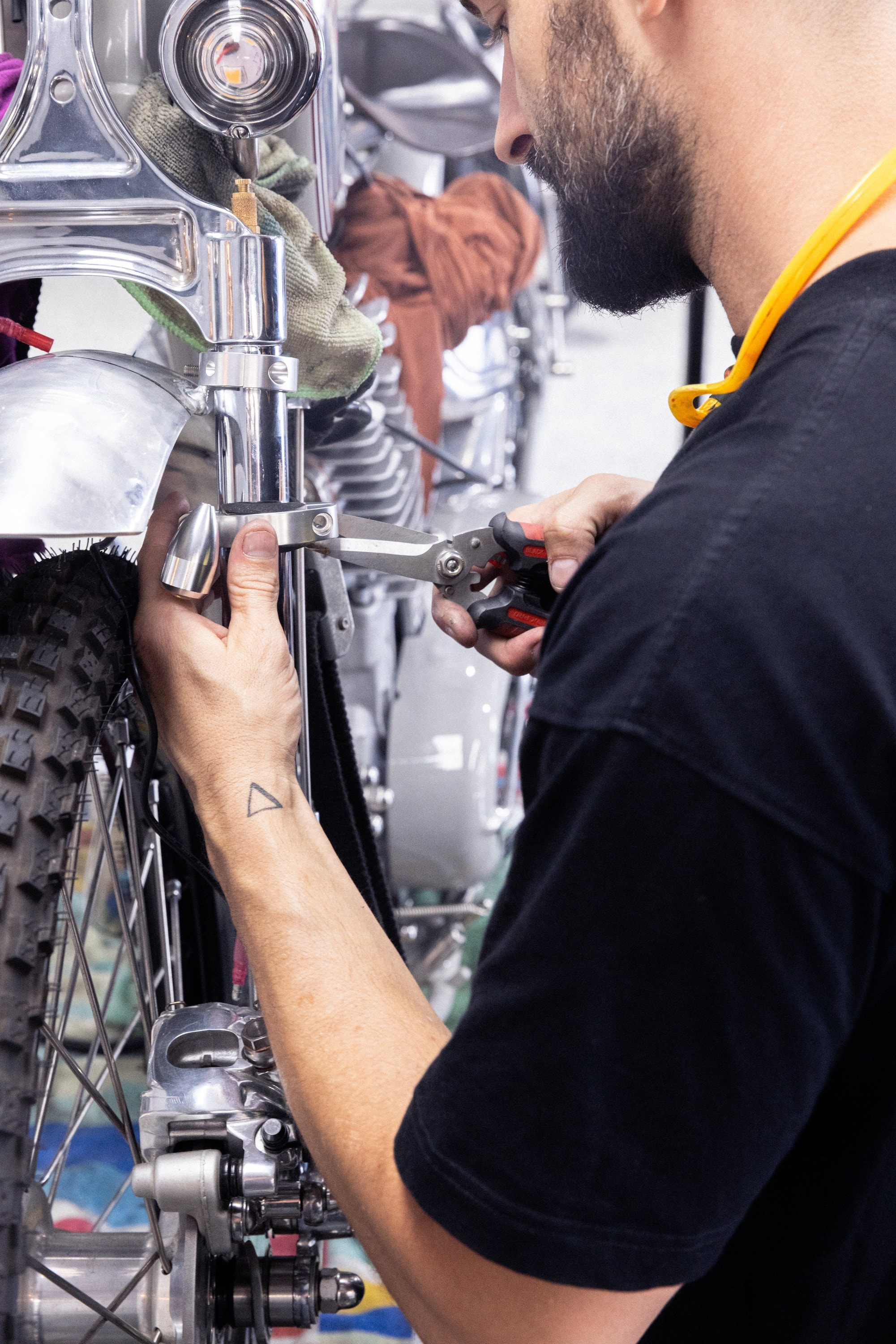 Tom Gilroy tightening a fitting on the front forks of a custom bike