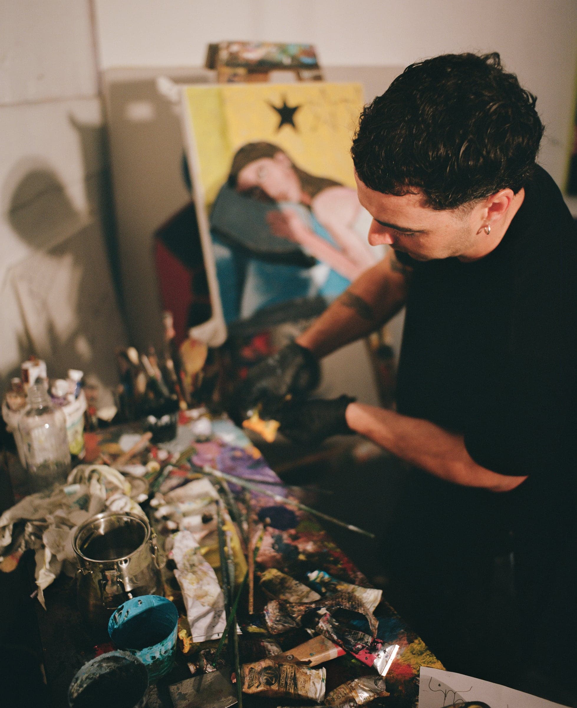 Chris mixing paint at his table, shot on film